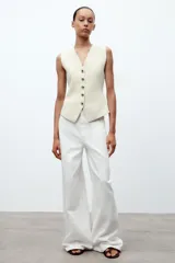 Chaleco color verde claro de punto con escote pico y cierre frontal con botones dorados.