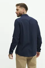 Camisa de lino color beige, de manga larga, corte semi slim y logo bordado en el pecho.
