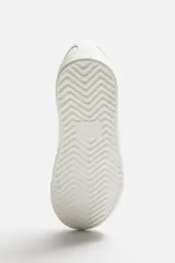 Zapatillas urbanas bajas color blanco, con cordones y suela plana.