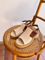 Sandalias de cuero color beige con detalles en marrón, plataforma y tobillera regulable.