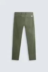 Pantalón chino color beige, corte skinny fit, confeccionado en tejido con mezcla de algodón y elasticidad. Cuenta con bolsillos frontales y traseros. Cierre frontal con cremallera y botón.