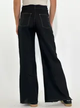 Pantalón de jean blanco de corte ancho con aberturas laterales en el ruedo y costuras a contratono.