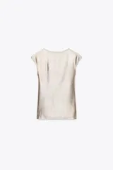 Camiseta dorada de cuello redondo y manga corta, con tejido metalizado.