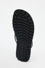 Sandalia plana de piel color negro, con tiras delanteras y suela de goma.