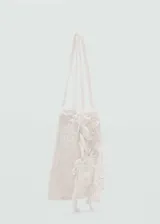 Bolso blanco de crochet con apliques florales y doble asa corta.