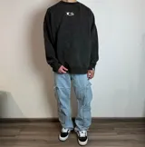 Buzo negro de corte oversize con estampado de cuatro recuadros con diseños de plantas en la espalda.
