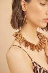 Conjunto de collar y caravanas color dorado, con diseño de ramas.