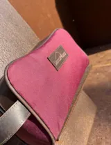 Neceser de lona verde con detalles en cuero color beige y etiqueta con logo de la marca Sierra Mora.