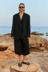 Bermuda negra de lino y rayón con elástico en la cintura, largo a media pantorrilla, tiro bajo y fit oversized en A.