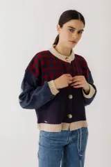 Cárdigan marrón con diseño de rombos en tonos rojizos y beige. Tiene cuello redondo, cierre frontal con botones y mangas largas con puños acanalados.