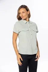 Camisa color salmón de lino, de corte clásico, con cuello camisero, manga corta, cierre frontal con botones y dos bolsillos de parche en el pecho.