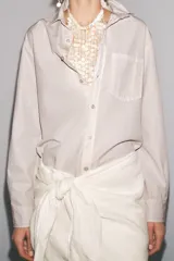 Camisa color crudo de corte recto, con cuello clásico, manga larga con puños abotonados, cierre frontal con botones y bolsillo de parche en el pecho.