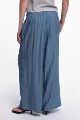 Pantalón de tela color celeste con textura arrugada, corte amplio y cintura elastizada.