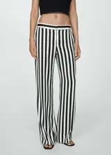 Pantalón largo de mujer con estampado de rayas verticales en blanco y negro, corte recto y bajo con vuelta.