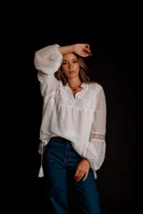 Camisa blanca de plumetí con cuello mao, mangas largas abullonadas con puños elásticos y cordón con borlas en el escote.