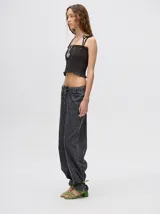 Top corto negro con textura fruncida, tirantes finos con lazos ajustables y corte crop.