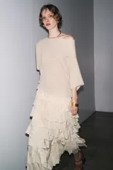 Falda midi color verde oliva confeccionada en tejido con viscosa. Presenta cintura elástica y detalle de volantes en el mismo tejido.