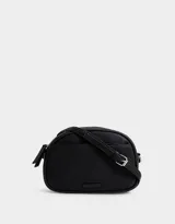 Bandolera negra de cuerina con bolsillo frontal con tag de metal, correa regulable, cierre superior y tirador de material principal.