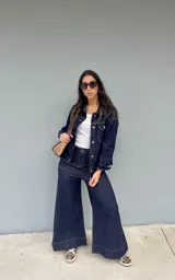Pantalón de mezclilla azul oscuro con corte amplio y costuras contrastantes.