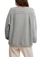 Remera de manga larga color gris con textura acanalada, cuello redondo, hombros caídos, puños y costuras marcadas con terminaciones sin rematar.