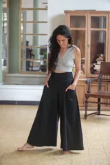 Pantalón palazzo negro de algodón con corte evasé, tiro alto, bolsillos laterales, elástico en la espalda y faja ancha.