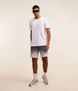 Bermuda deportiva masculina con cintura elástica, cordón interno de ajuste y forro de malla. Diseño con cuadros difuminados en degrade de gris oscuro a blanco.
