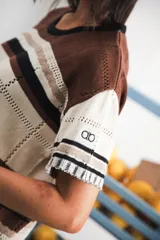 Vestido largo de tejido calado con rayas horizontales en color crudo, azul marino y rojo. Tiene tajo lateral y logo bordado en la manga.