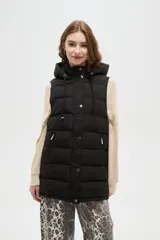 Chaleco puffer negro con capucha ajustable, cierre frontal con botones a presión y bolsillos laterales con cierre.