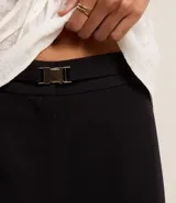 Pantalón negro de sastrería, corte palazzo, con elástico en la cintura trasera y cinturón con hebilla metálica.