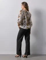 Blusa de gasa verde con estampado floral blanco y celeste, cuello a la base con escote en V y mangas 3/4 fruncidas.