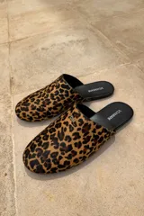 Slippers con estampado animal print, forro y plantilla de cuero negro.