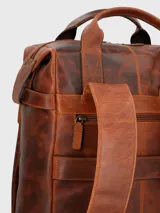 Mochila de cuero color marrón con doble asa de mano y correas acolchadas ajustables. Presenta un compartimento principal con cierre de cremallera, bolsillo acolchado interior para laptop, bolsillo interior con cierre, dos bolsillos frontales con cierre lateral, bolsillo trasero con cierre y forro interior de poliéster reciclado.