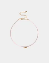 Gargantilla choker de terciopelo rosa con dije de mariposa dorada y cierre de mosquetón.