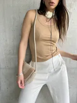 Musculosa de morley color beige, con tirantes finos y ajuste ceñido al cuerpo.