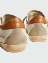Championes Golden Goose modelo Super Star, color blanco con detalles en marrón y estrella en gris.