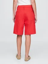 Short de jean color rojo, corte a la rodilla.