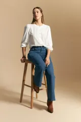 Jean oxford de tiro alto, color azul oscuro, con costuras frontales marcadas y corte acampanado progresivo desde la rodilla.