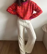 Pantalón de punto color crema, de corte recto y tiro alto, con diseño de trenzas verticales.