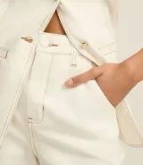 Short de sarga color blanco, tiro alto, corte mom, con botón forrado, bolsillos laterales y costuras contrastantes.