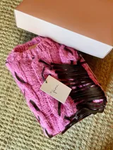 Sweater tejido de lana mohair color rosa con intervención de tiras de cuero napa ovina color marrón.
