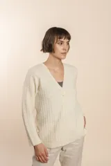 Cardigan tejido con efecto fantasia color crema. Una prenda de silueta amplia y cómoda. Tejido en 100% lana fina sin teñir.