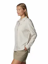 Camisa de manga larga color beige claro, con cuello clásico, cierre frontal con botones y dos bolsillos en el pecho. Confeccionada con tejido transpirable con protección solar FPS 50 y tecnología Omni-Wick™ para absorción de la humedad.