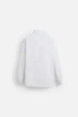 Camisa blanca de corte regular, cuello italiano, manga larga con puños abotonados y cierre frontal con botones.