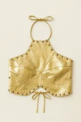 Top halter dorado de cuero ovino genuino, con diseño panelado y tachas en oro viejo. Se ajusta en la espalda con tres tiras y en la parte inferior con lazos.