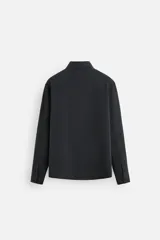 Camisa negra relaxed fit confeccionada en tejido fluido con mezcla de viscosa. Tiene cuello solapa, manga larga con puño abotonado y cierre frontal con botones.
