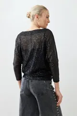 Blusa negra de mangas 3/4 con lentejuelas.