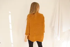 Sweater color ocre de lana de cordero con cuello alto abotonado y calce oversize.