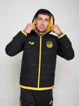 Campera de abrigo corta negra con capucha y costuras en contraste color amarillo. Estampado del escudo del Club Atlético Peñarol en el pecho y en la espalda.