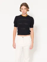 Sweater negro tejido en bucle, con mangas cortas abullonadas y espalda con abertura.