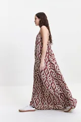 Vestido largo de poliéster con estampado geométrico en tonos borgoña, beige y blanco. Tiene breteles finos y escote redondeado con frunces sutiles en la parte delantera y trasera.